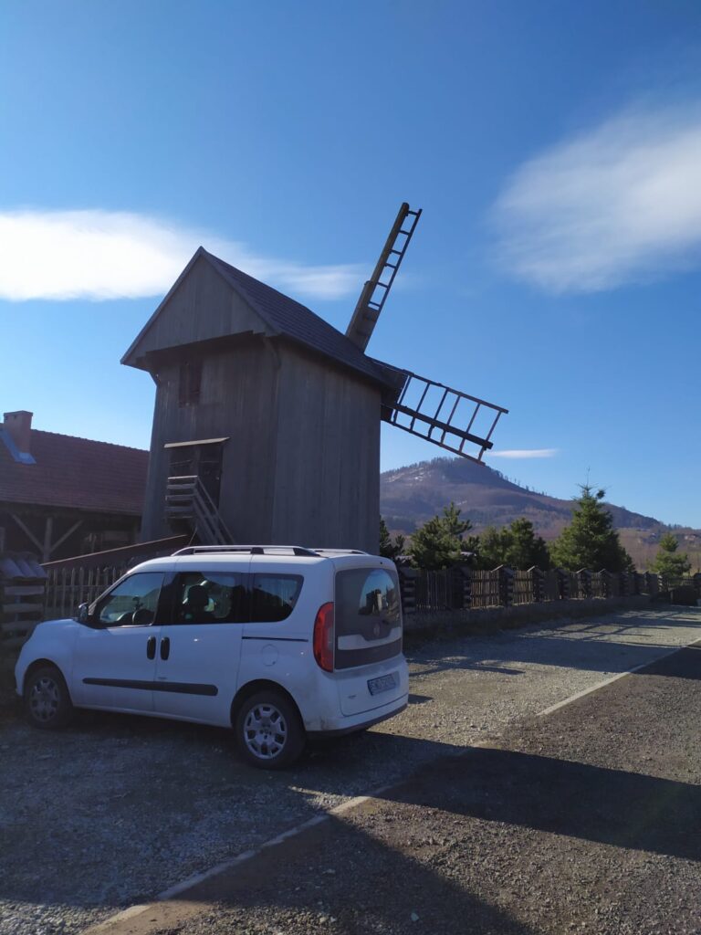 Na zdjęciu krajobraz górski z wiatrakiem.