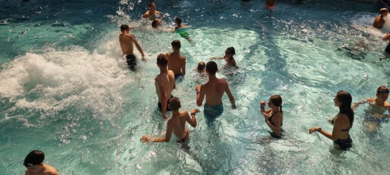 Grupa wychowanków bawi się w basenie.