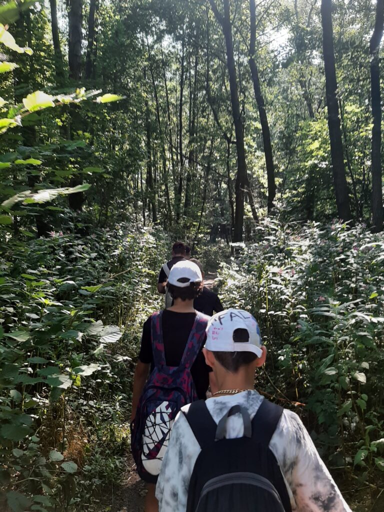 Wychowankowie spacerują w lesie.