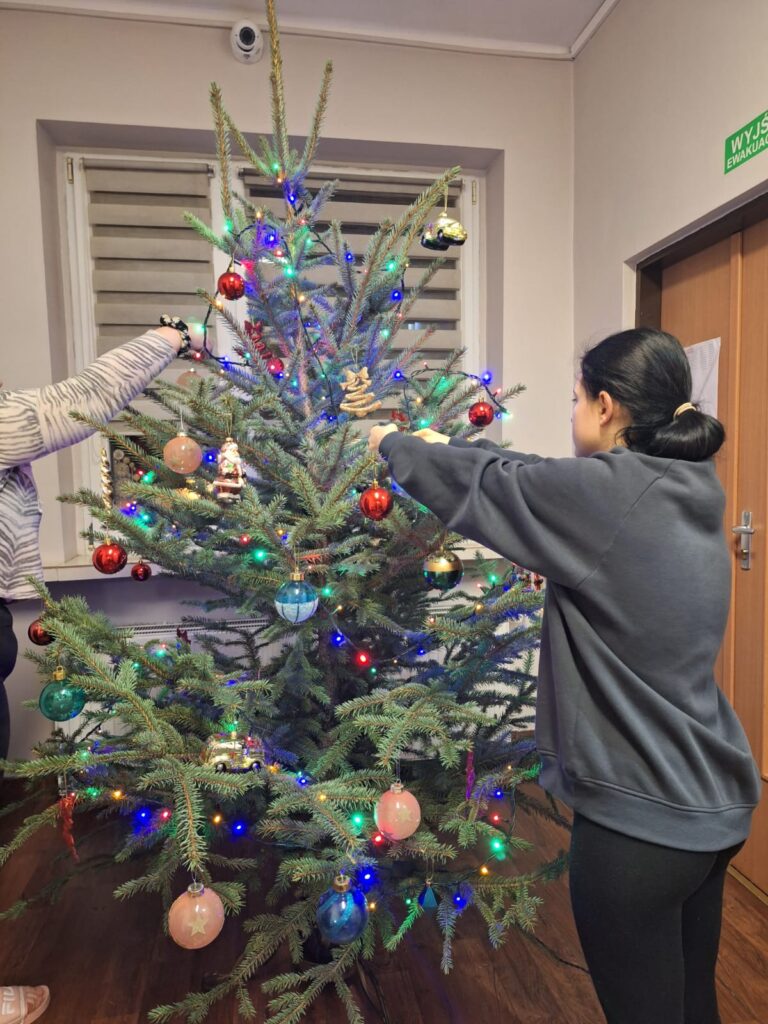 Wychowankowie ubierają choinkę na święta Bożego Narodzenia.